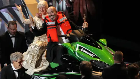 Reuters Mark Bridges and Dame Helen Mirren on a jet ski at the Oscars