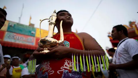 AFP Performer with a kettle piercing his cheek