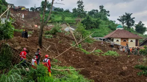 Antara Foto/Novrian Arbi/Reuters Indonesian Red Cross searched for victims buried by landslides in Sumedang, West Java Province, Indonesia, 10 January 2021