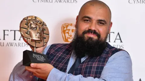 BAFTA Chris Roberts winner of the Presenter Award for 'Bwyd Byd Epic Chris' at the 2022