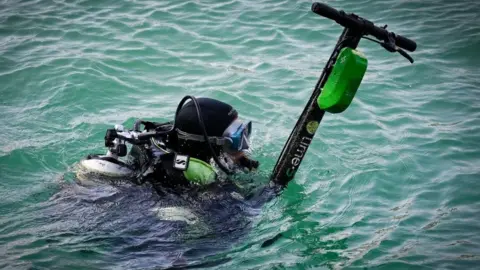 Getty Images An e-scooter belonging to US firm Lime is fished out of the sea in Marseille