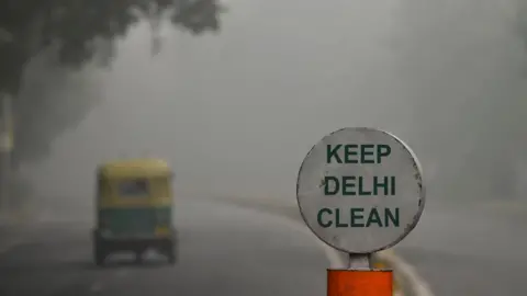 AFP A sign reading "Keep Delhi clean" with a thick smog in the background