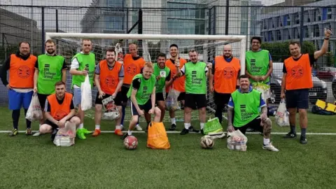 Football For Foodbanks CIC Football players by the goal bringing their food donations