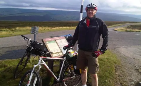 Collings family David Collings standing beside his bike in the countryside