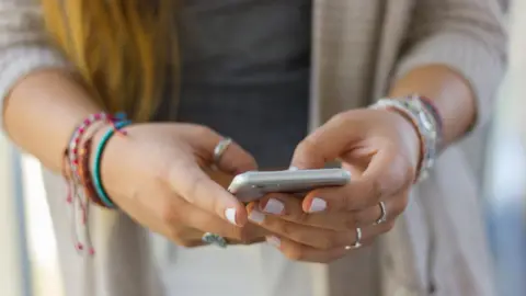 Getty Images Teenage girl using social media