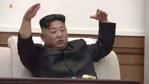 Korean Central Television Kim Jong-un gestures with a cigarette in his hand