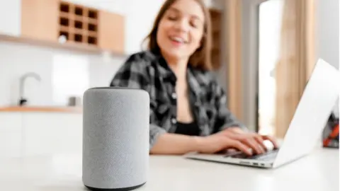 Getty Images A woman looking at her voice assistant