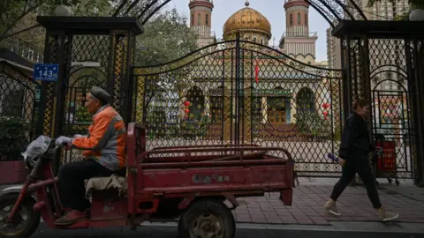 Getty Images This photo taken on September 11, 2019 shows people walking past a mosque in Urumqi, the regional capital of Xinjiang.