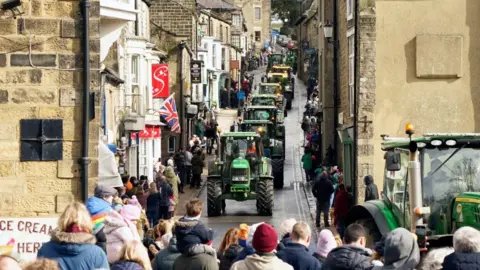 Danny Lawson/PA A convoy of tractors travel through Pateley Bridge