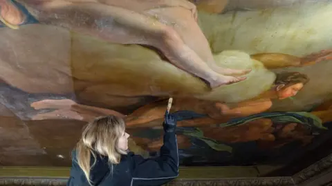Boughton House Conservator Marta Sledz working on ceiling painting at Boughton House