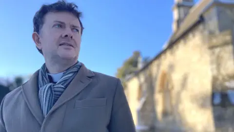 Deiniol Heywood next to his church Holy Trinity, where the Prestwood foodbank operates from