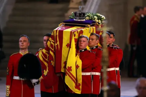 PA Media Pallbearers carrying the Queen's coffin into Westminster Hall