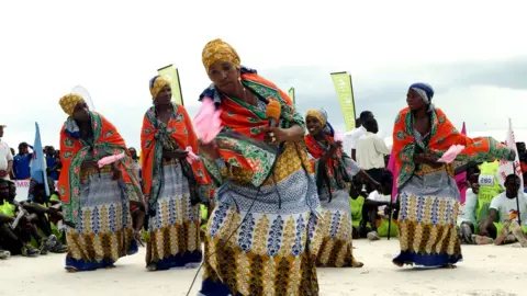 Catherine Tilke The cyclists finish at Vumawimbi beach with much fanfare. Here, women dance dressed in colourful kangas.