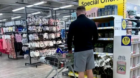 BBC Man browsing shelves at supermarket