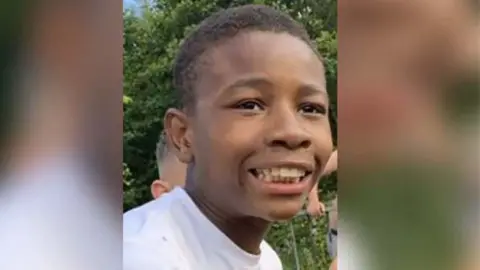 Family photo A family photo of Christopher Kapessa smiling in a white T-shirt