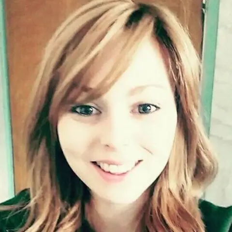 Katie Hawthorne a woman with long hair smiles at camera