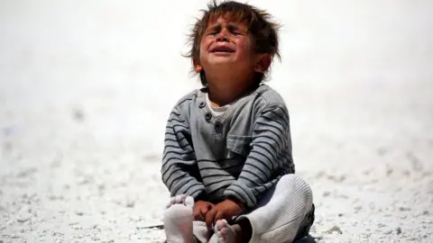 AFP A child cries at a camp for displaced people in Ain Issa, Syria (10 June 2017)