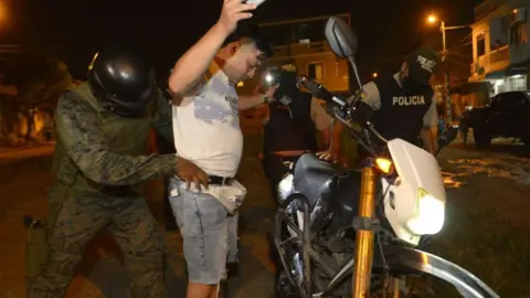 Getty Images A soldier frisks a local in Cerro Las Cabras, a canton located in the province of Guayas, Ecuador, on April 29, 2022