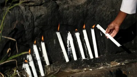 Reuters A member of The Golden Apostolic Faith Healing Mission Church lights candles during a religious ceremony to celebrate Good Friday.