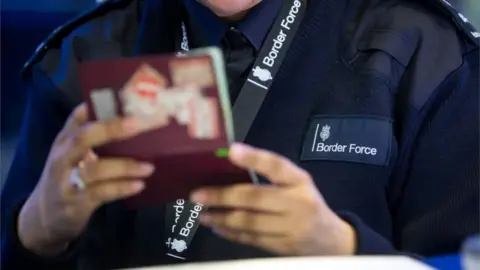 PA Border Force officer checking passport