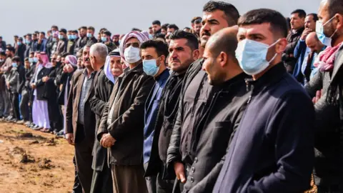 Getty Images People gather for the mass funeral in Kocho on 6 February 2021