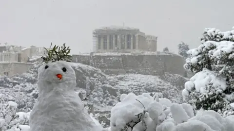 AFP A snowman is pictured with the Parthenon temple atop the Athenian Acropolis hill