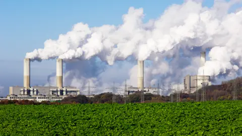 Getty Images Power plant and green field