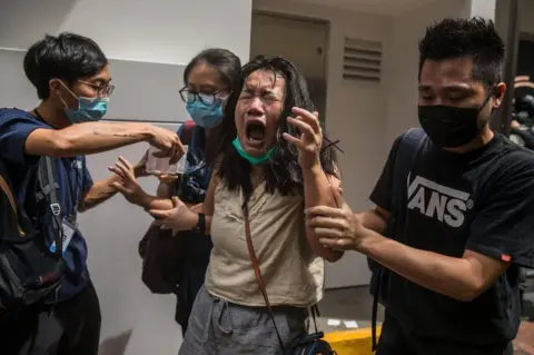 DALE DE LA REY/AFP A woman reacts after she was hit with pepper spray