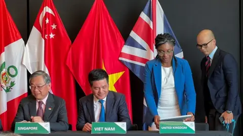 Reuters Singapore's Minister for Trade and Industry Gan Kim Yong, Vietnam's Minister of Trade and Industry Nguyen Hong Dien and British Secretary of State for Business and Trade Kemi Badenoch on the day the UK signs the treaty to join the CPTPP