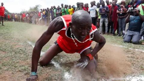 Reuters A Maasai Moran falls after throwing a javelin