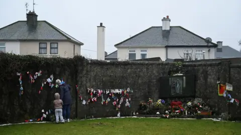 REUTERS/Clodagh Kilcoyne Mourners pay their respects to the Tuam babies in County Galway