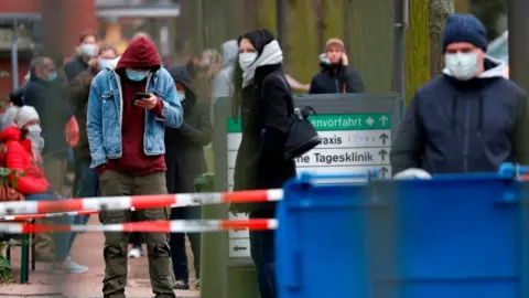 Getty Images People outside a building in Germany waiting to get tested for Covid-19