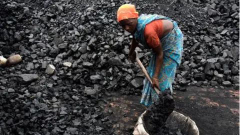 Getty Images Woman shovels coal in Kamduni brick kiln. Kamduni, West Bengal, India 08.03.17 The brick kilns of Bengal employ a large number of laborers from distant villages of Bihar, Orissa and Uttar Pradesh