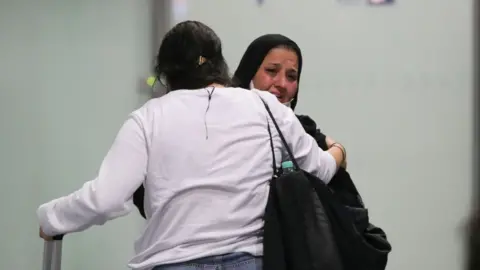 Getty Images A woman weeps as she arrives among the first German and Afghan evacuees from Kabul, at Frankfurt International Airport