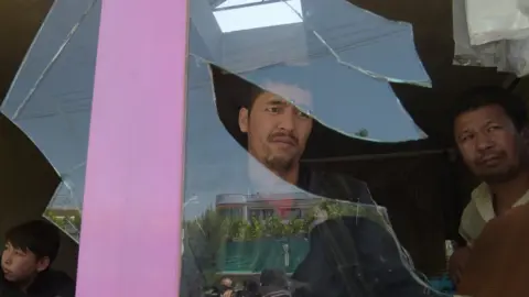 Shah Marai / AFP Afghan residents inspect the site of a suicide bombing outside a voter registration centre in Kabul on 22 April 2018