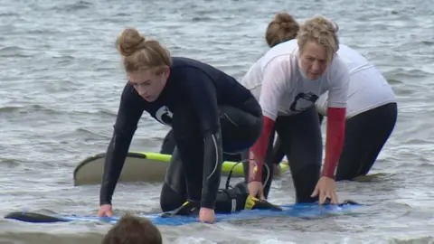 Layla Cuthill with instructor doing surf therapy