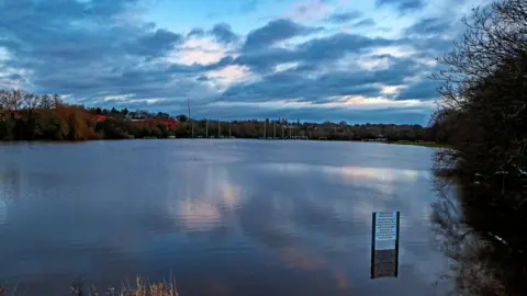 PA Media Submerged playing fields in Didsbury, Manchester