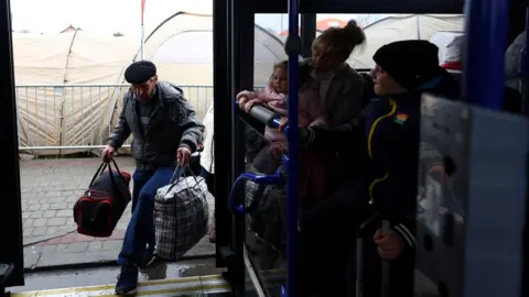 Reuters A Ukrainian refugee boards a bus, bound for Przemysl after crossing the Ukraine-Poland border