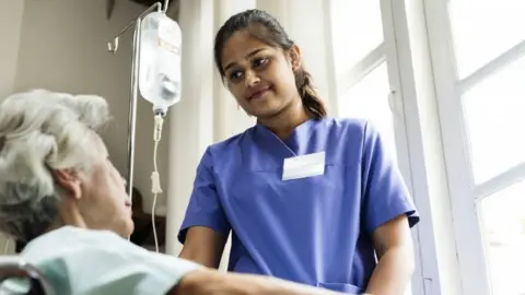 Getty Images Nurse tends to patient