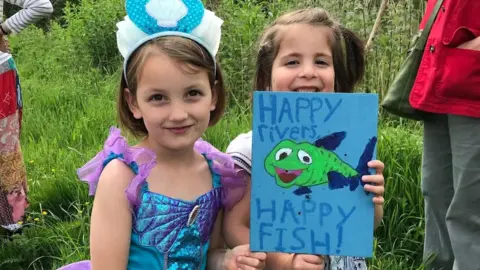 Caroline Speca Two children holding a sign