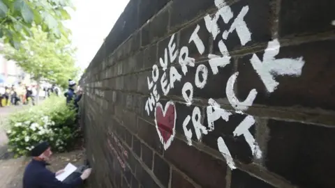 Reuters An anti-fracking protester writes messages on a wall in Lancashire