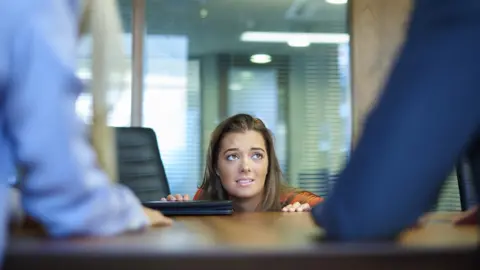 Getty Images Woman coming out from under desk