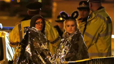 Reuters Two fans watch on outside an ambulance