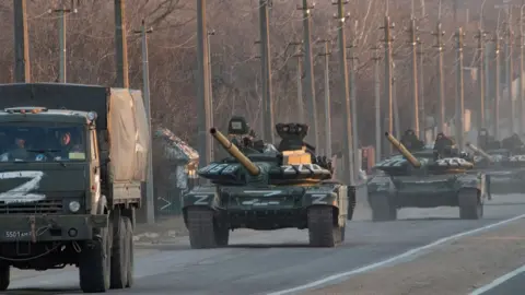 SOPA Images A column of tanks marked with the Z symbol stretches into the distance as they proceed northwards along the Mariupol-Donetsk highway in March.