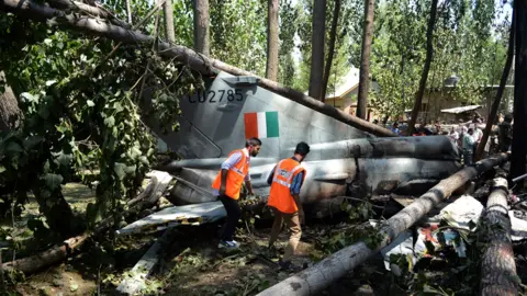 AFP Disaster response personnel walk next to the wreckage of an Indian Air Force MiG-21 Bison aircraft that crashed in Soibugh on the outskirts of Srinagar on August 24, 2015.