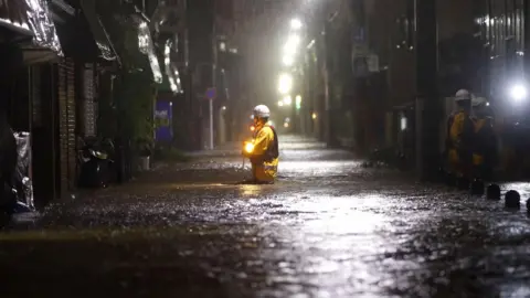 Kyodo/via REUTERS Firefighters patrol on a flooded road due to heavy rains caused by Typhoon Hagibis in Tokyo, Japan, 12 October, 2019.