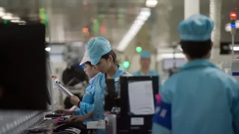 Getty Images Workers build smartphone chip component circuits at the Oppo factory in Dongguan