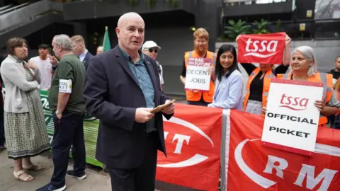 PA Media Mick Lynch, general secretary of the Rail, Maritime and Transport union (RMT) on the picket line outside London Euston train station