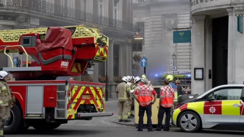 Firefighters gather near the fire at Admiralty pub