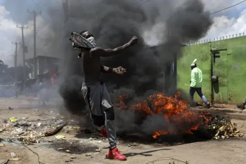 Daniel Irungu / EPA-EFE A supporter of the opposition Azimio coalition throws stones towards police (not pictured) during a nationwide protest in Nairobi, Kenya